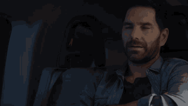 a man in a car with his eyes closed