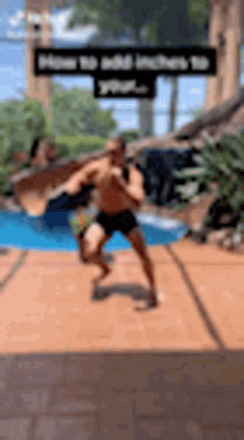 a shirtless man is running in front of a pool .