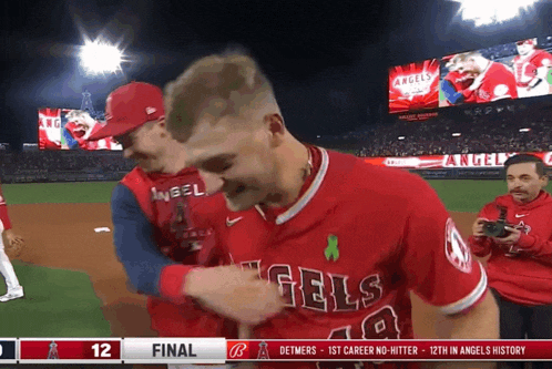 a man in a red angels jersey is being congratulated by another man