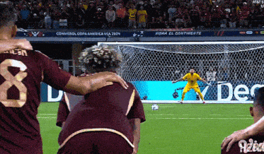 a soccer player with the number 8 on his back is hugging another player