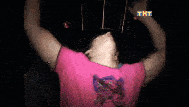 a man in a pink shirt is making a heart with his hands in front of the tht logo