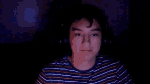 a man wearing headphones is making a funny face while giving the middle finger .