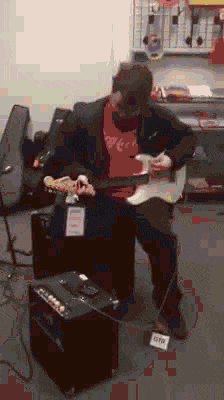 a man in a coca cola shirt plays a guitar