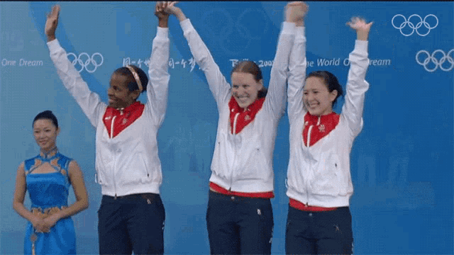 a group of female athletes are raising their arms in the air