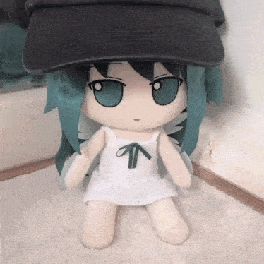 a stuffed doll is wearing a hat and a white dress