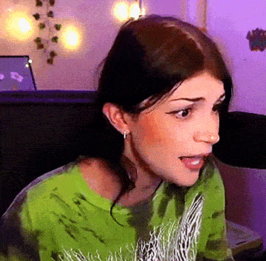a woman wearing a green shirt with a zebra print on it is talking into a microphone