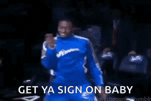 a man in a blue suit is dancing with the words `` get ya sign on baby '' behind him .