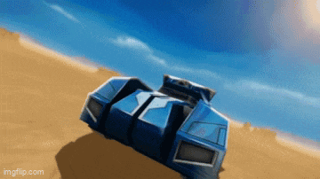 a blue car is driving down a sandy road with a blue sky in the background .