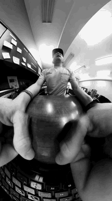 a man wearing a t-shirt that says ' abercrombie & fitch ' on it is holding a bowling ball