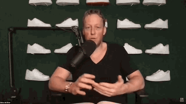 a man speaking into a microphone with the words repeat after me behind him