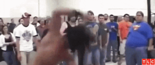 a group of people are standing in a room with tlc written on the bottom