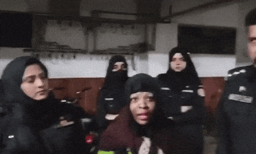 a woman with pink lips is standing in front of a group of police officers