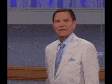 a man in a suit and tie is making a face .
