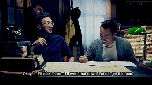 two men are sitting at a desk and one of them says " okay i 'll make sure i 'll write that down "