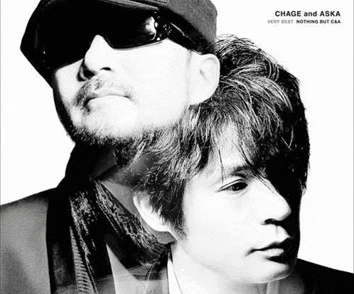 a black and white photo of two men wearing sunglasses and hats .