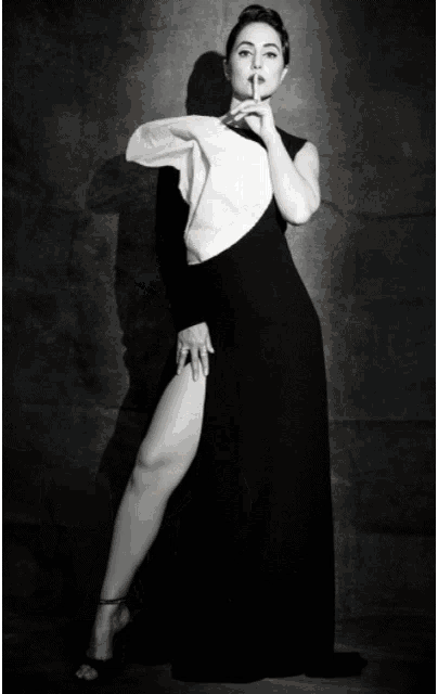 a woman in a black and white dress with a high slit on the side