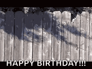 a wooden fence with the words `` happy birthday '' written on it .
