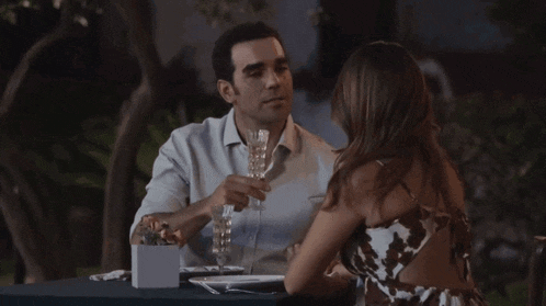 a man and a woman are toasting with glasses