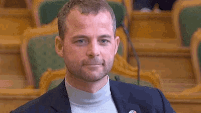 a man in a suit has a badge on his jacket that says ' united states '