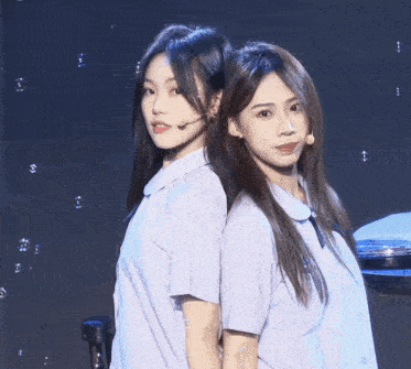two girls standing back to back with bubbles behind them