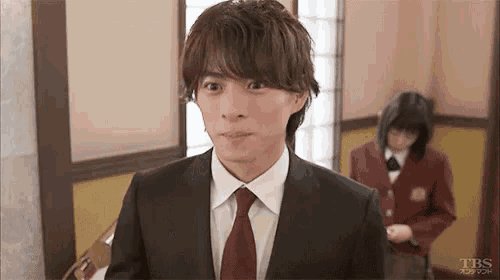 a man in a suit and tie is making a funny face in a room .