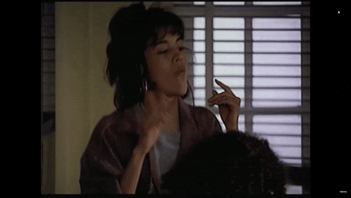 a woman is making a funny face in front of a window ..