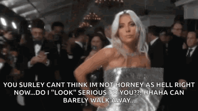 lady gaga is standing in front of a crowd of people .