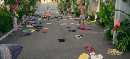 a bunch of clothes are scattered on the ground in a driveway