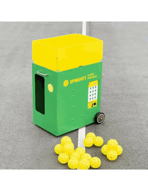 a green box that says spinshot on it is filled with yellow balls