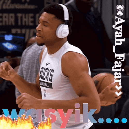 a man wearing headphones and a bucks jersey