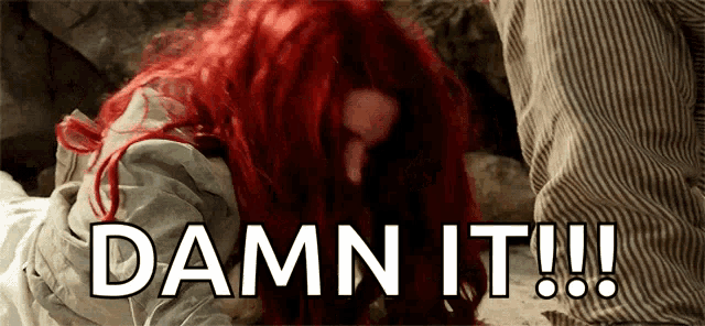 a woman with red hair is laying on the ground with the words damn it !