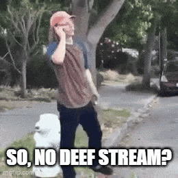 a man is talking on a cell phone while standing on the side of the road .