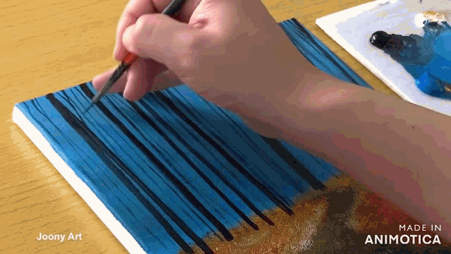a person is painting on a canvas with a brush and the words made in animatica on the bottom right