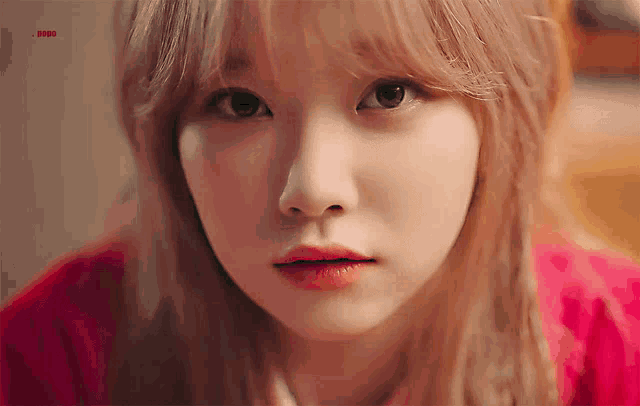 a close up of a woman 's face with a red background that says snbb