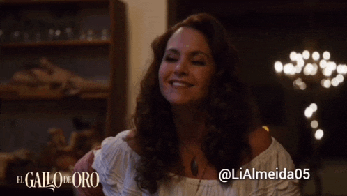 a woman is smiling in front of an el gallo de oro poster