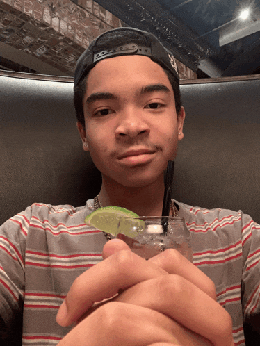 a young man holding a drink with a straw