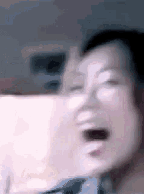 a blurry picture of a woman laughing with her mouth wide open