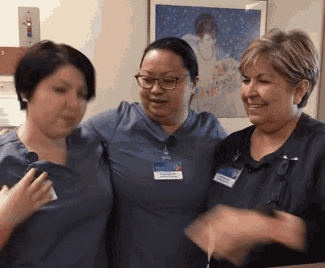 three nurses are posing for a picture and one of them has a name tag that says ' marie ' on it
