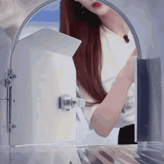 a woman in a white shirt is standing in a doorway