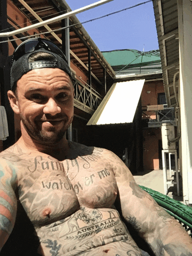 a man with a tattoo that says family watches over me