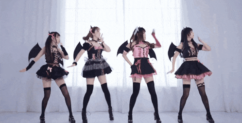 a group of women in devil costumes are dancing together