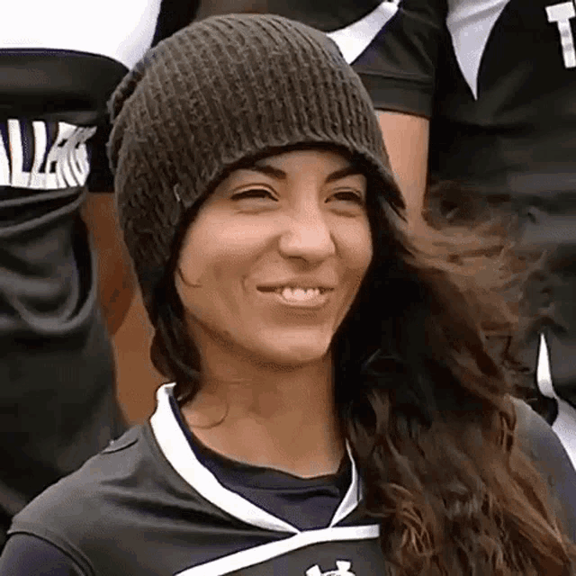 a woman wearing a beanie and a jersey that says t on it
