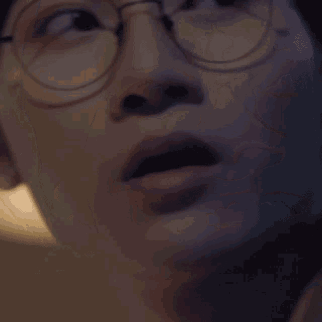 a close up of a man wearing glasses and smiling
