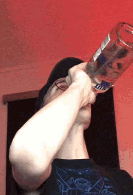a man is holding a bottle of bud light