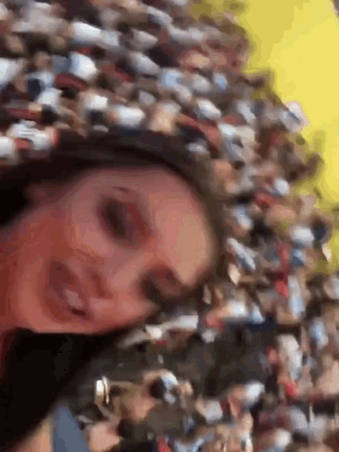 a woman is standing in front of a crowd of people and smiling