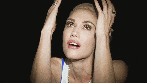 a woman with her hands on her head is wearing rings