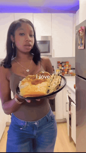 a woman holding a plate of food with the words i love written on it
