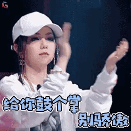 a woman wearing a white hat is clapping her hands in chinese