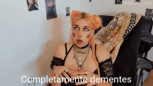 a woman sitting on a couch with the words completamente dementes on the bottom right