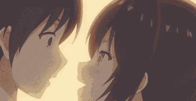 a boy and a girl are looking at each other in a close up of their faces .